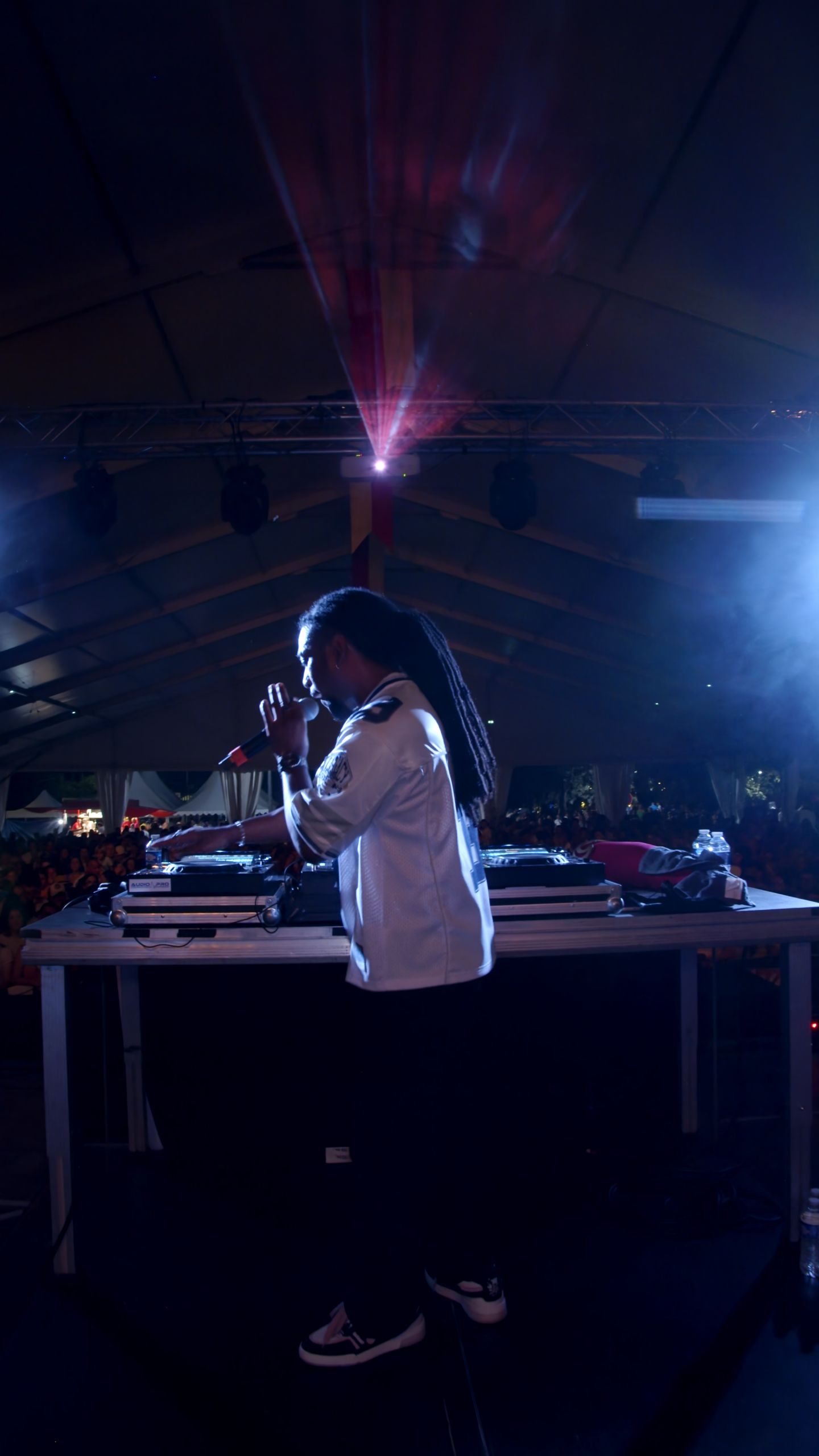 Un vidéaste à Bordeaux film Shad Hottaboy en pleine performance, avec des lumières et une foule en arrière-plan.